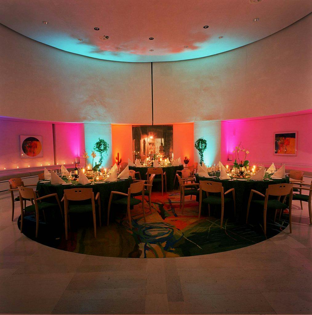 Elegant round table set for formal dinner in National Museum of Scotland event space.