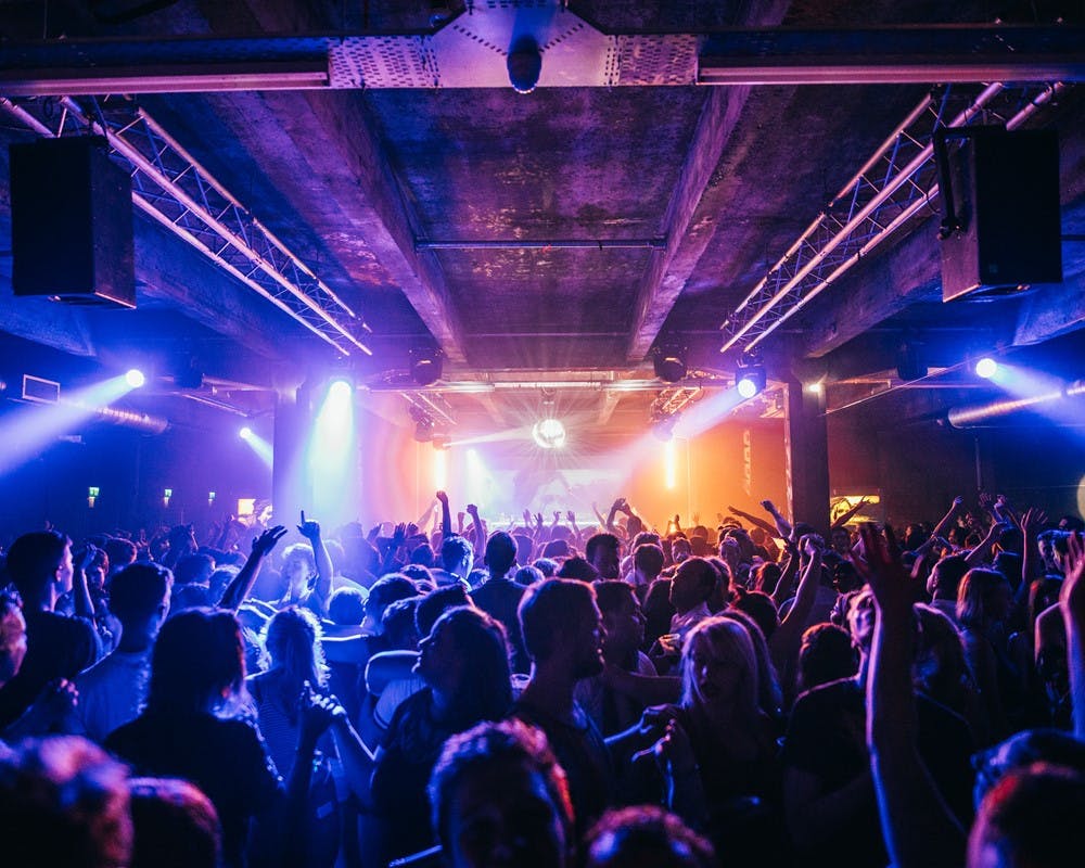 Vibrant SWG3 warehouse event space with dynamic lighting for concerts and nightlife.