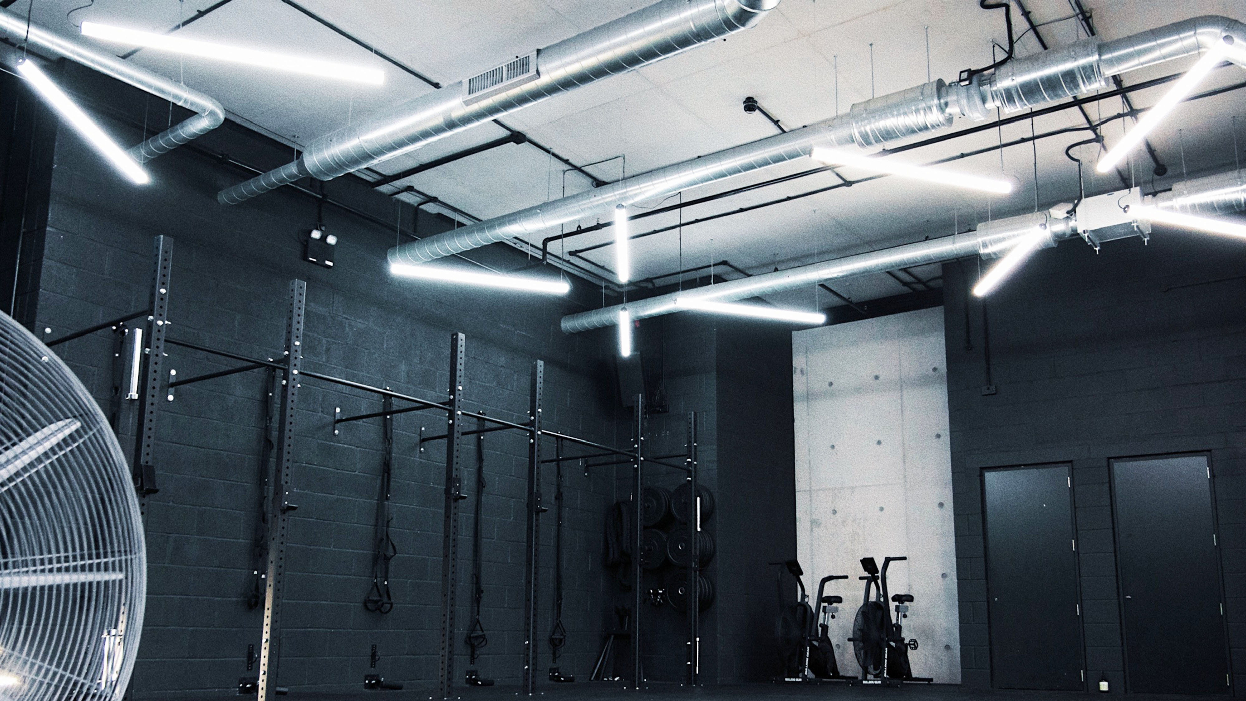 Modern industrial fitness space with exposed ductwork for health and wellness events. - Banner