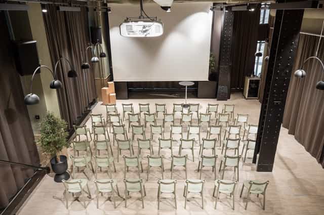 Event space in Provence with arranged chairs, projector, and welcoming lighting.