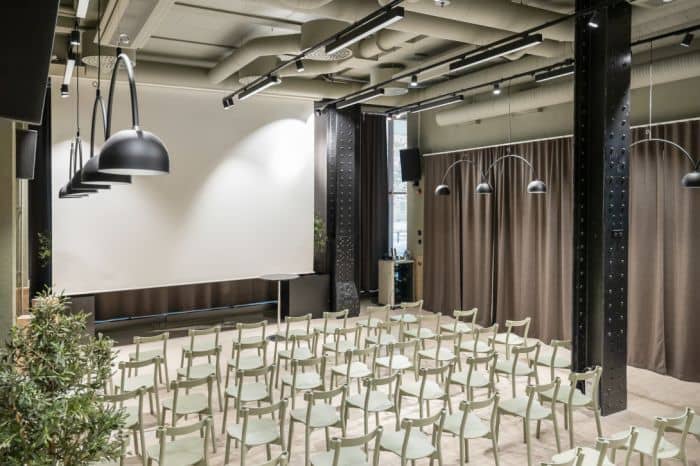 Meeting space in Provence with rows of chairs and a large projection screen for workshops.