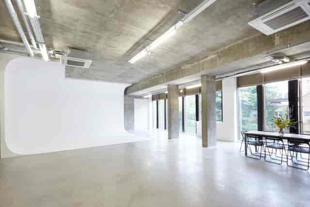 Modern industrial event space with concrete walls, ideal for workshops and presentations.