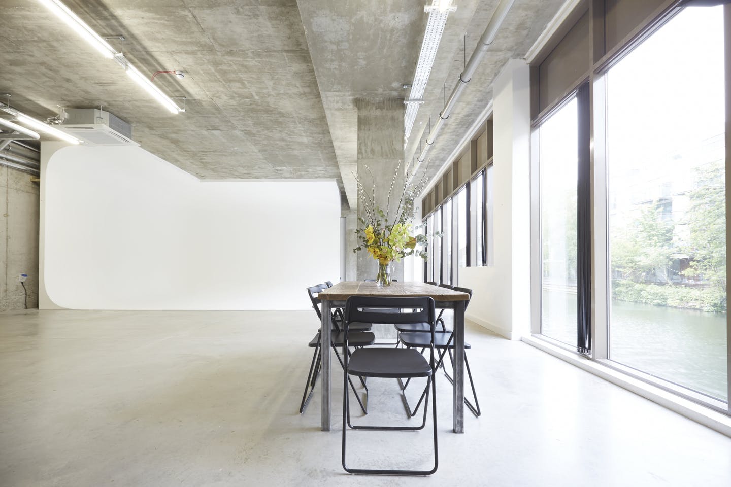 Modern minimalist meeting space with long table, ideal for brainstorming sessions.
