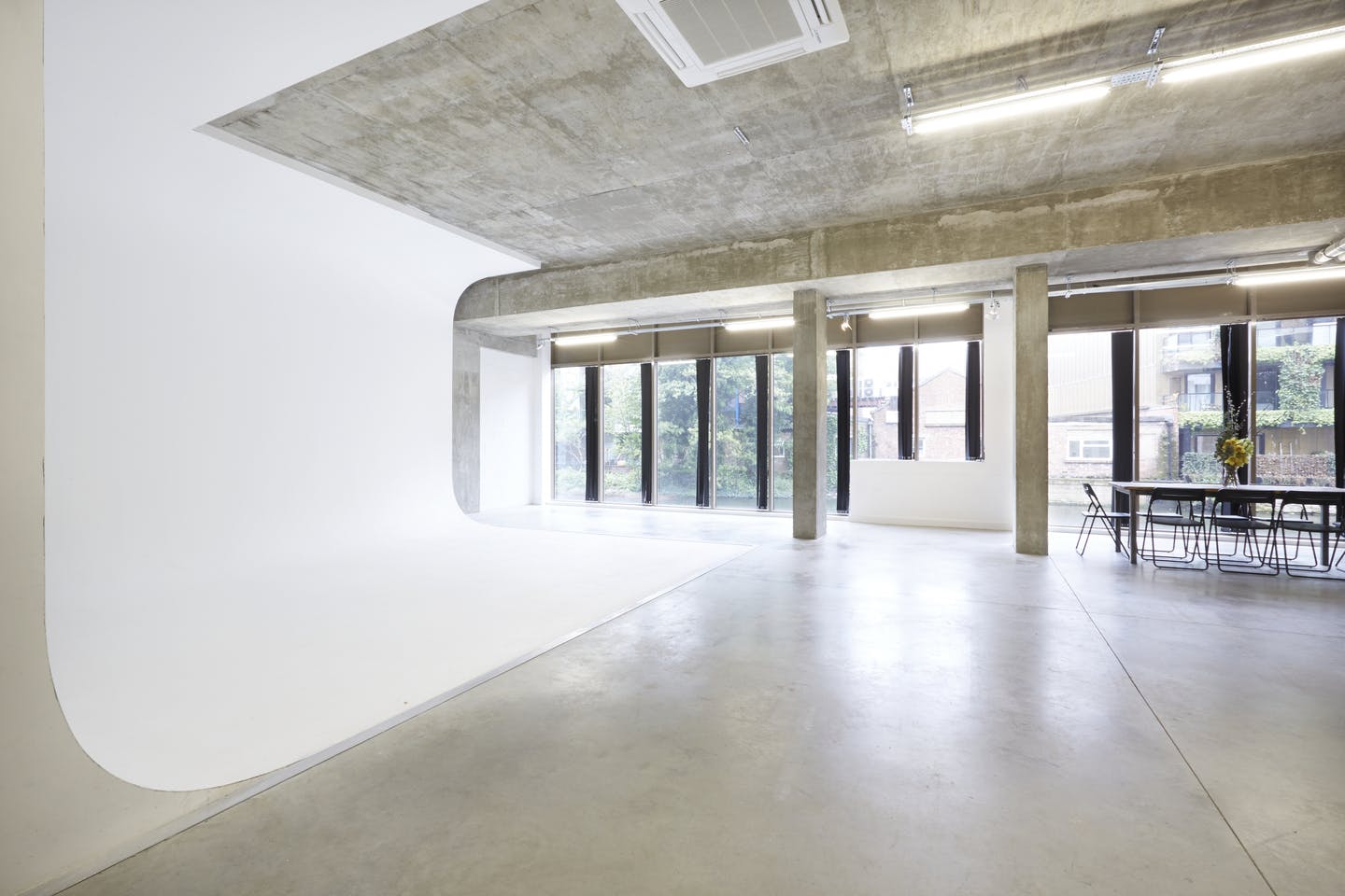 Versatile event space with white backdrop and natural light for corporate meetings and photo shoots.