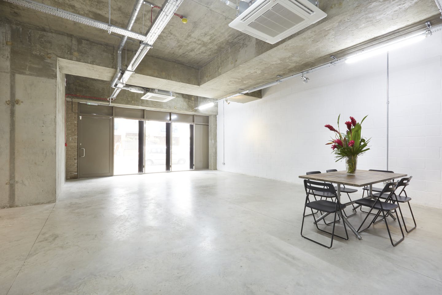 Versatile event space in LOCK Studios with natural light, ideal for workshops and gatherings.