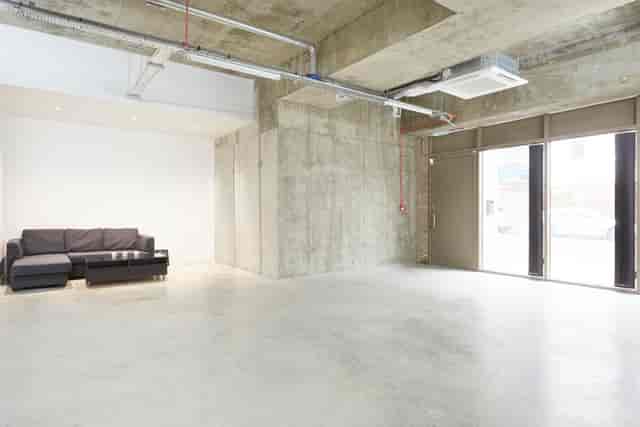 Versatile minimalist event space with concrete walls for meetings and workshops.