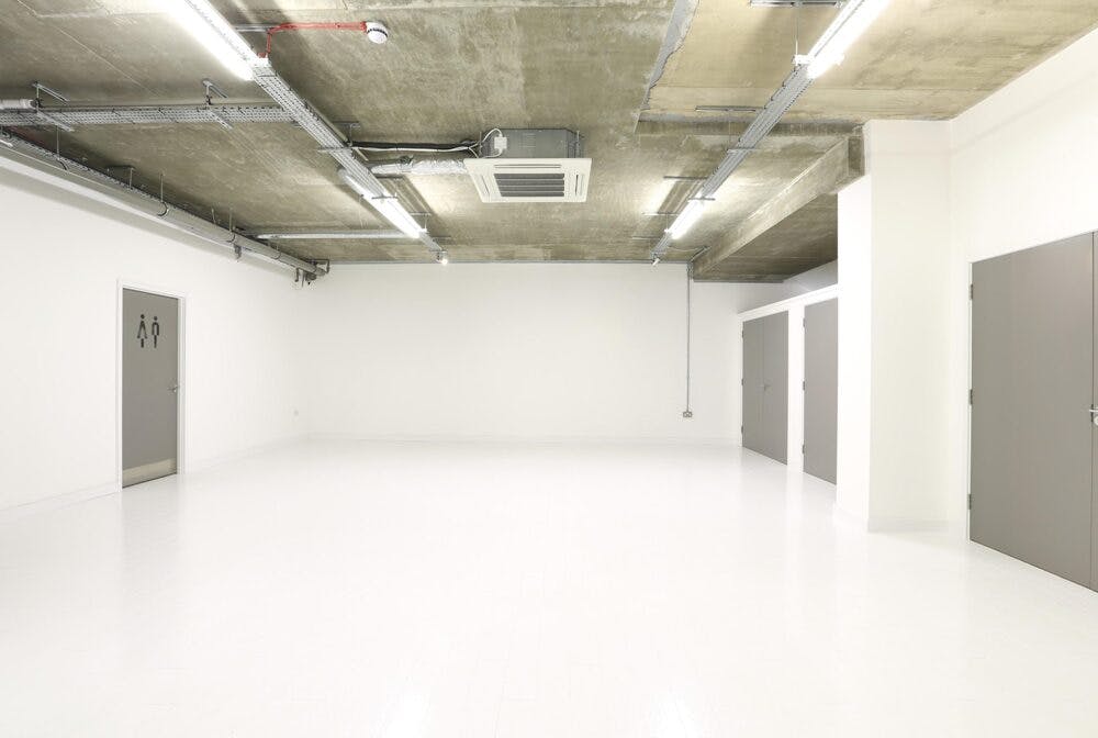 Versatile event space with polished white floor, ideal for corporate meetings and workshops.