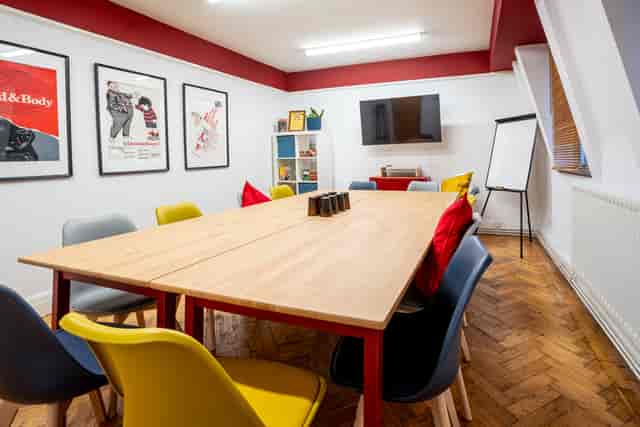 Conway Suite meeting room with wooden table, colorful chairs for creative events.