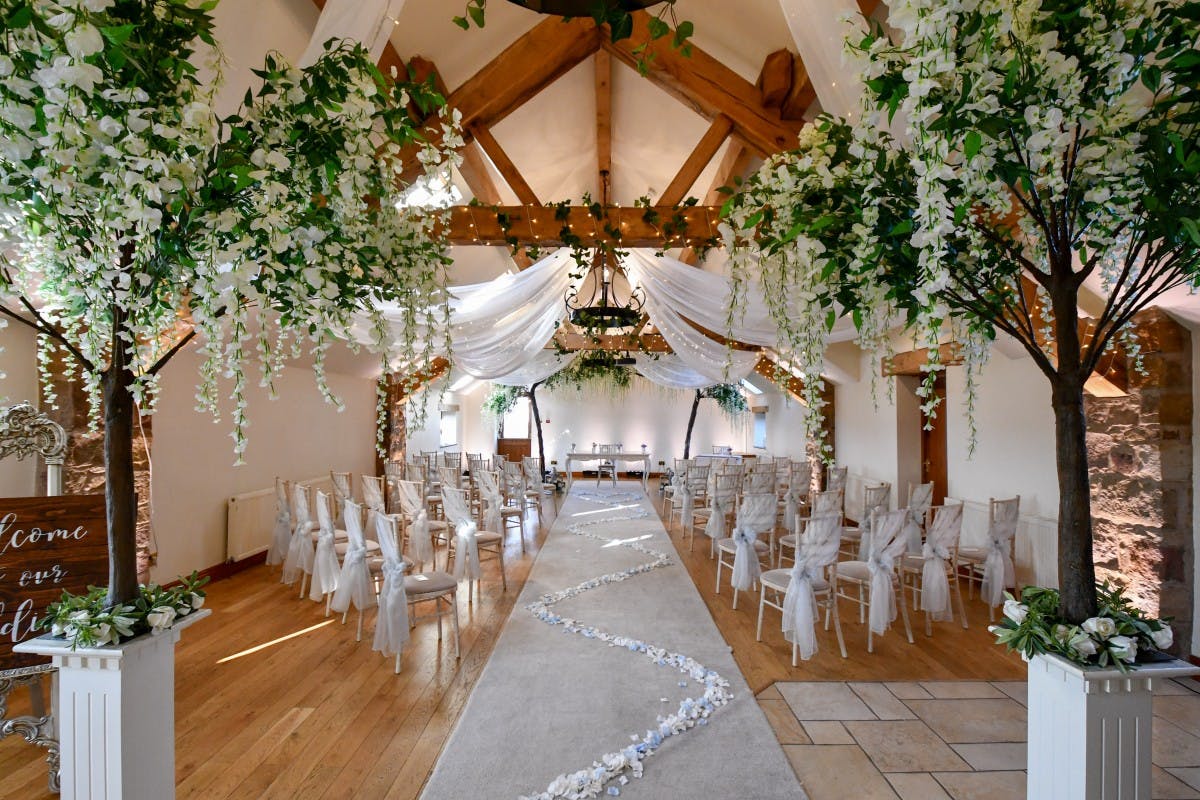 Elegant wedding venue at Beeston Manor with floral decor and wooden beams.