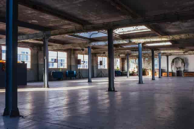 Spacious industrial venue with natural light, ideal for corporate events and workshops.