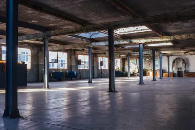 Spacious industrial venue with natural light, ideal for corporate events and workshops.