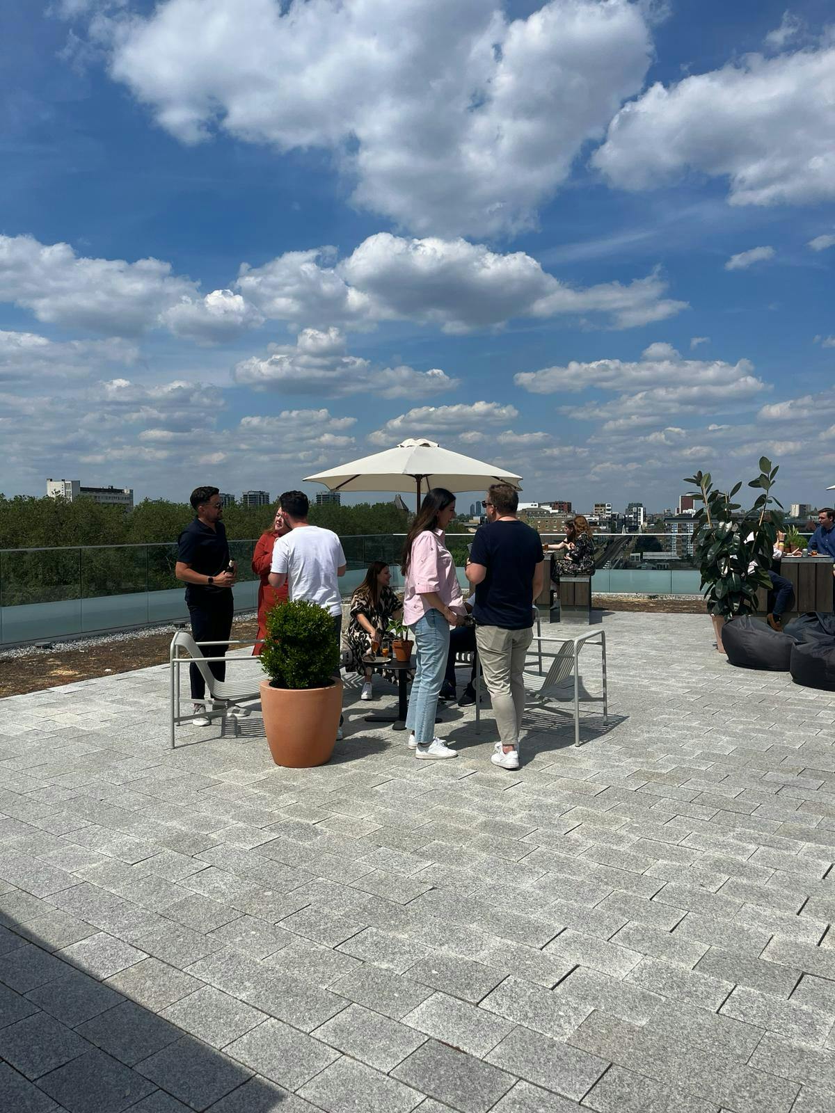 Outdoor networking event on a rooftop terrace in Shoreditch Exchange, vibrant atmosphere.
