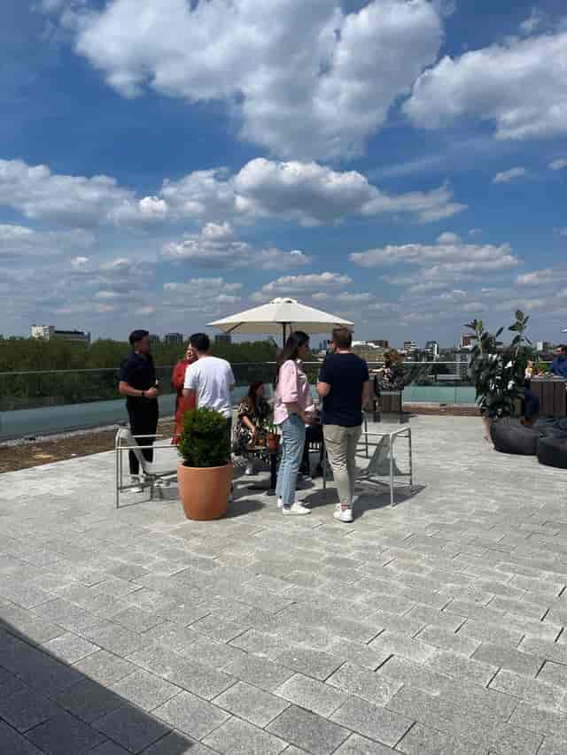 Outdoor networking event on a rooftop terrace in Shoreditch Exchange, vibrant atmosphere.