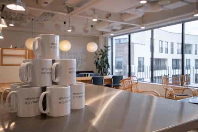 Modern Shoreditch Exchange meeting room with branded mugs, ideal for collaborative events.