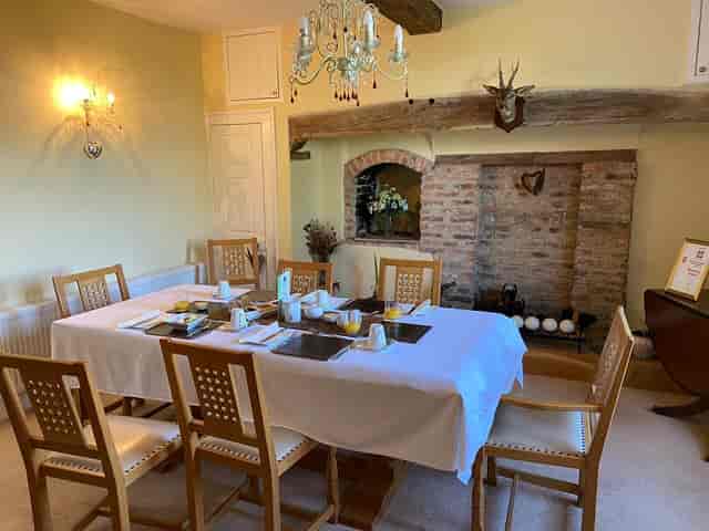 Intimate meeting space with elegant table settings and cozy fireplace at Low Osgoodby Grange.