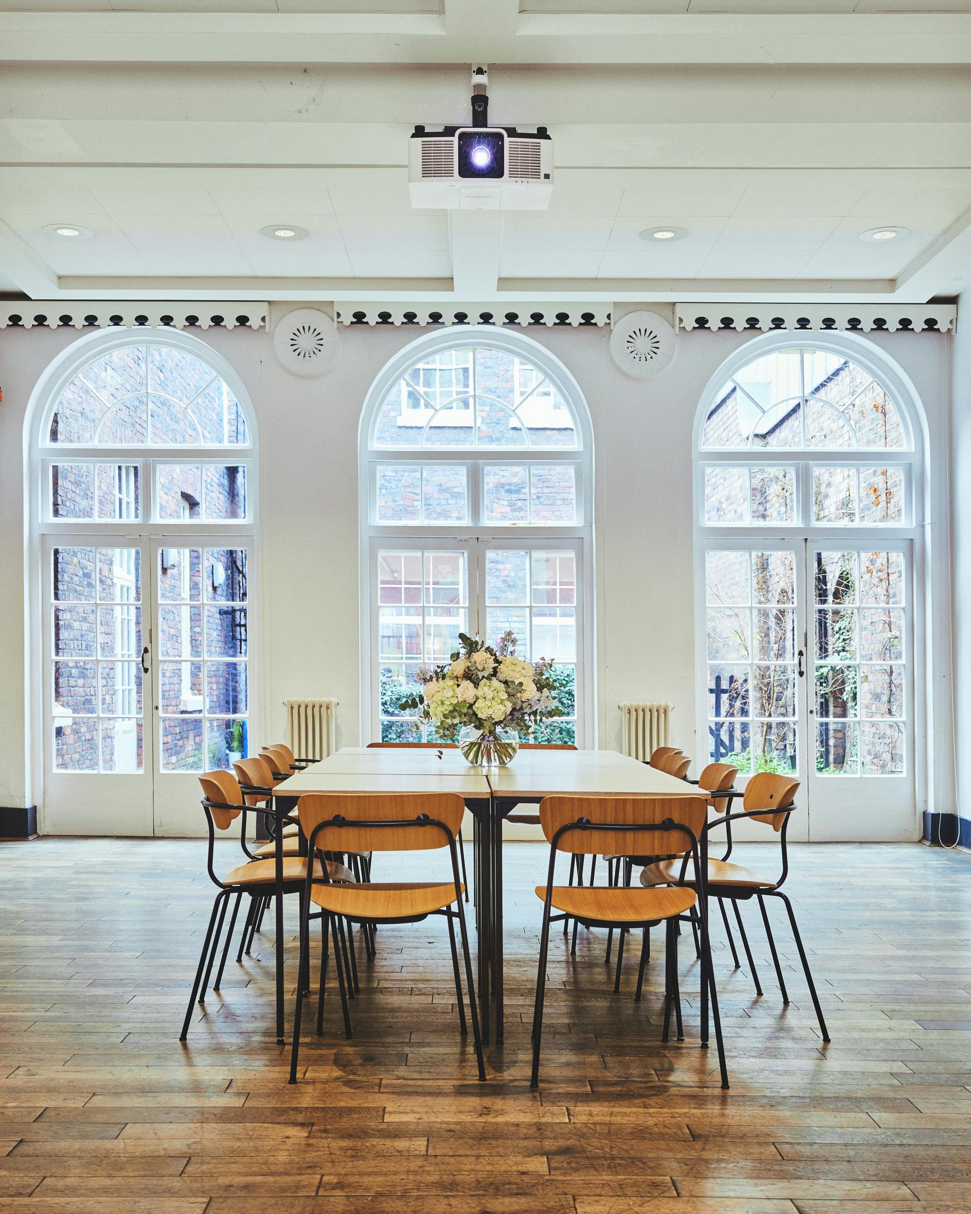 Bright meeting space in Sandon Room, The Bluecoat, with large windows and modern decor.