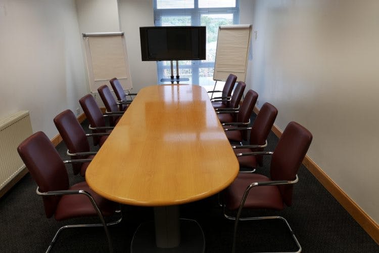 Café in Vine Conference Centre meeting room with wooden table, ideal for presentations and brainstorming.