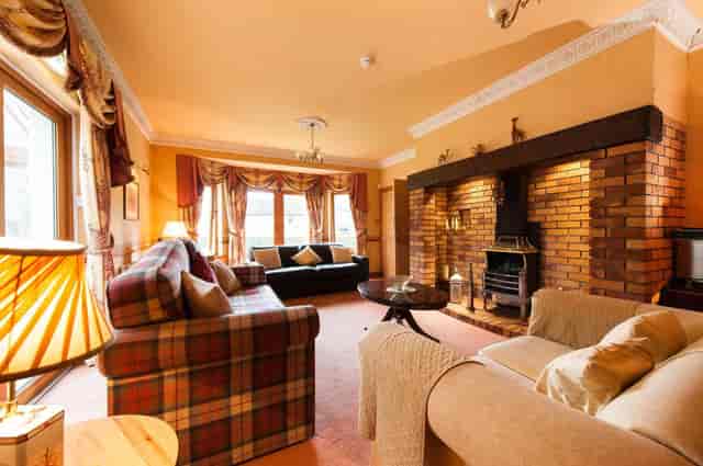 Cozy lounge area with fireplace at Kildonan Lodge Hotel for networking events.