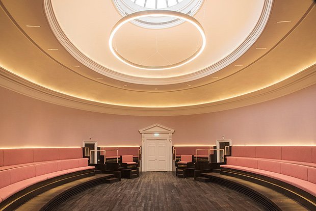 Modern meeting space in Laigh Hall with tiered seating and elegant pink accents.
