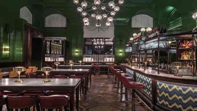 Stylish bar with green walls, ideal for cocktail receptions and networking events.