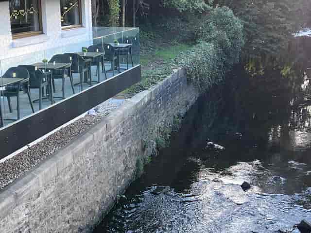 Serene outdoor terrace by waterway, perfect for casual meetings and networking events.
