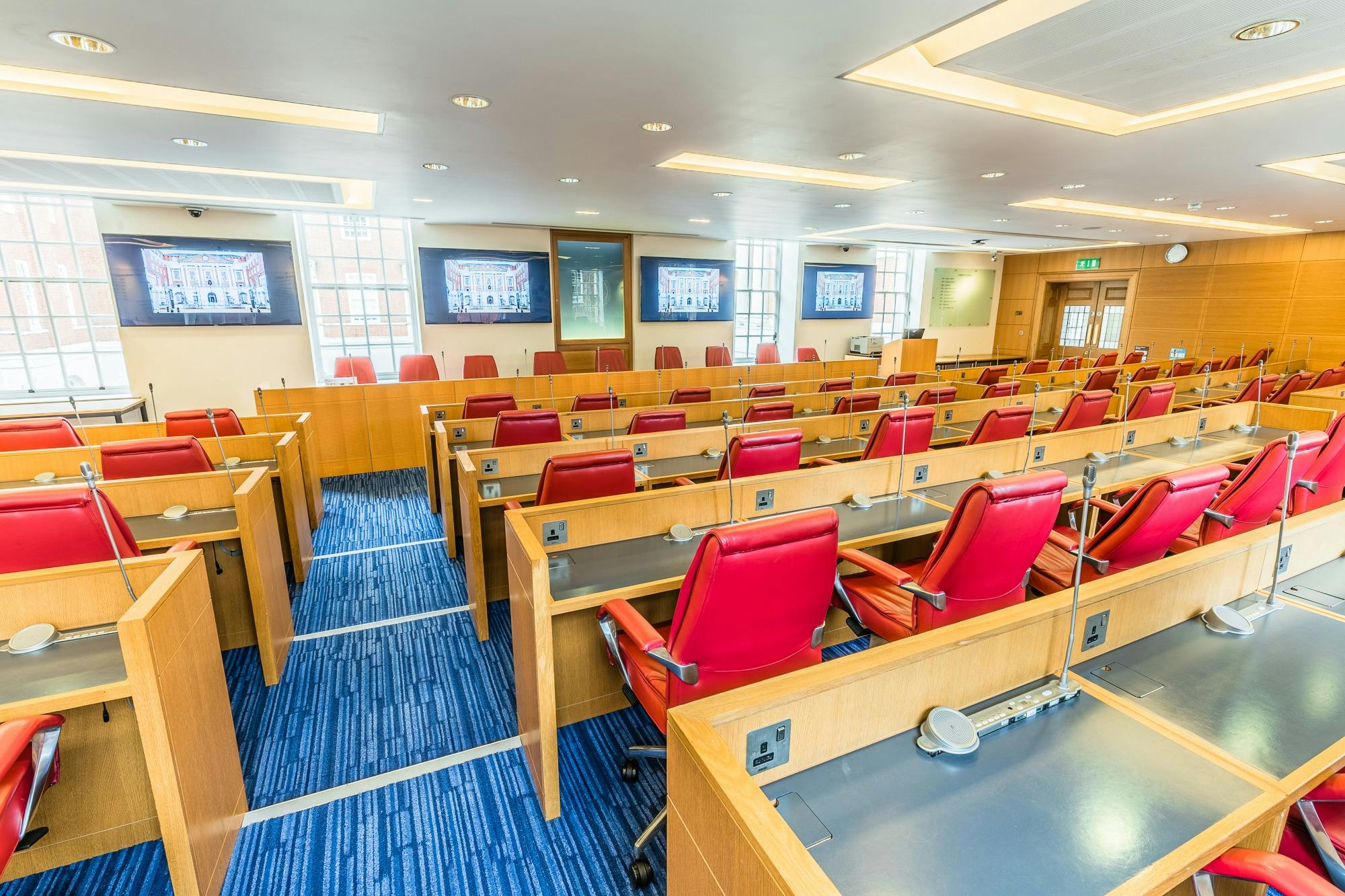 Modern Debating Chamber in BMA Scotland with red leather chairs, ideal for corporate events.