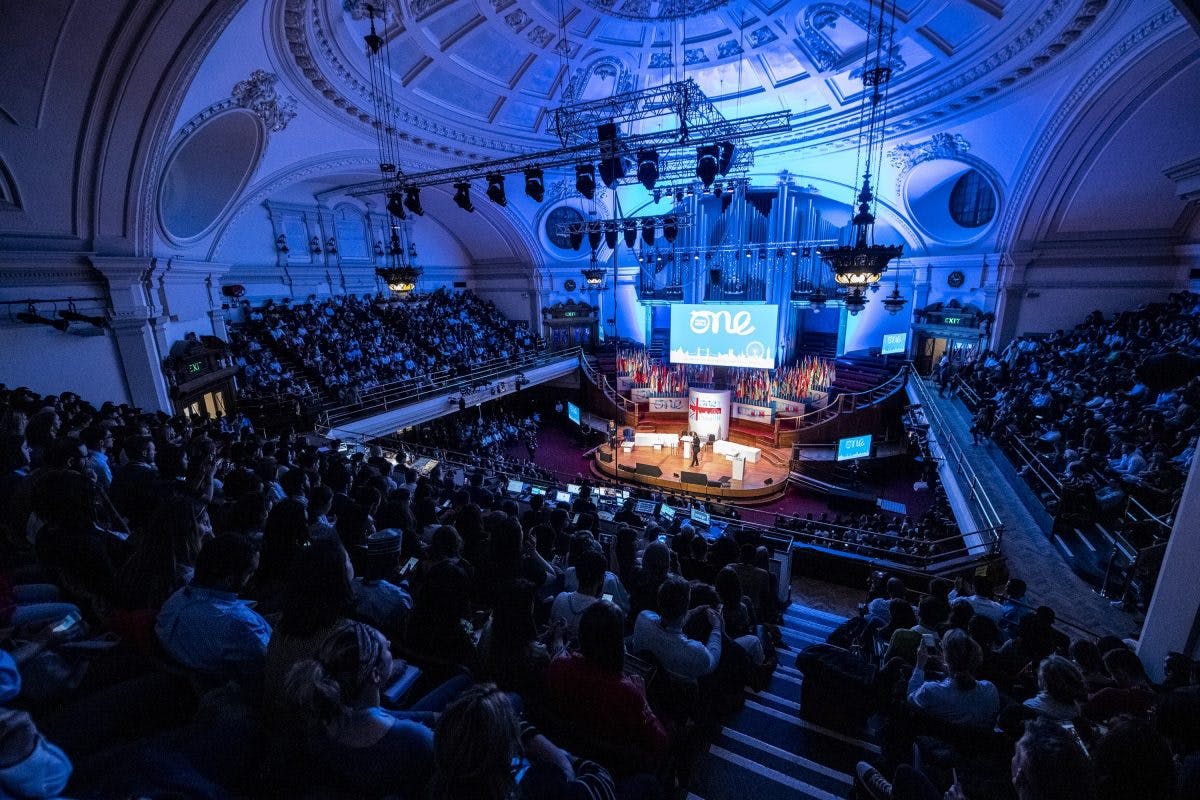 Packed auditorium with dynamic lighting for a large-scale networking event.