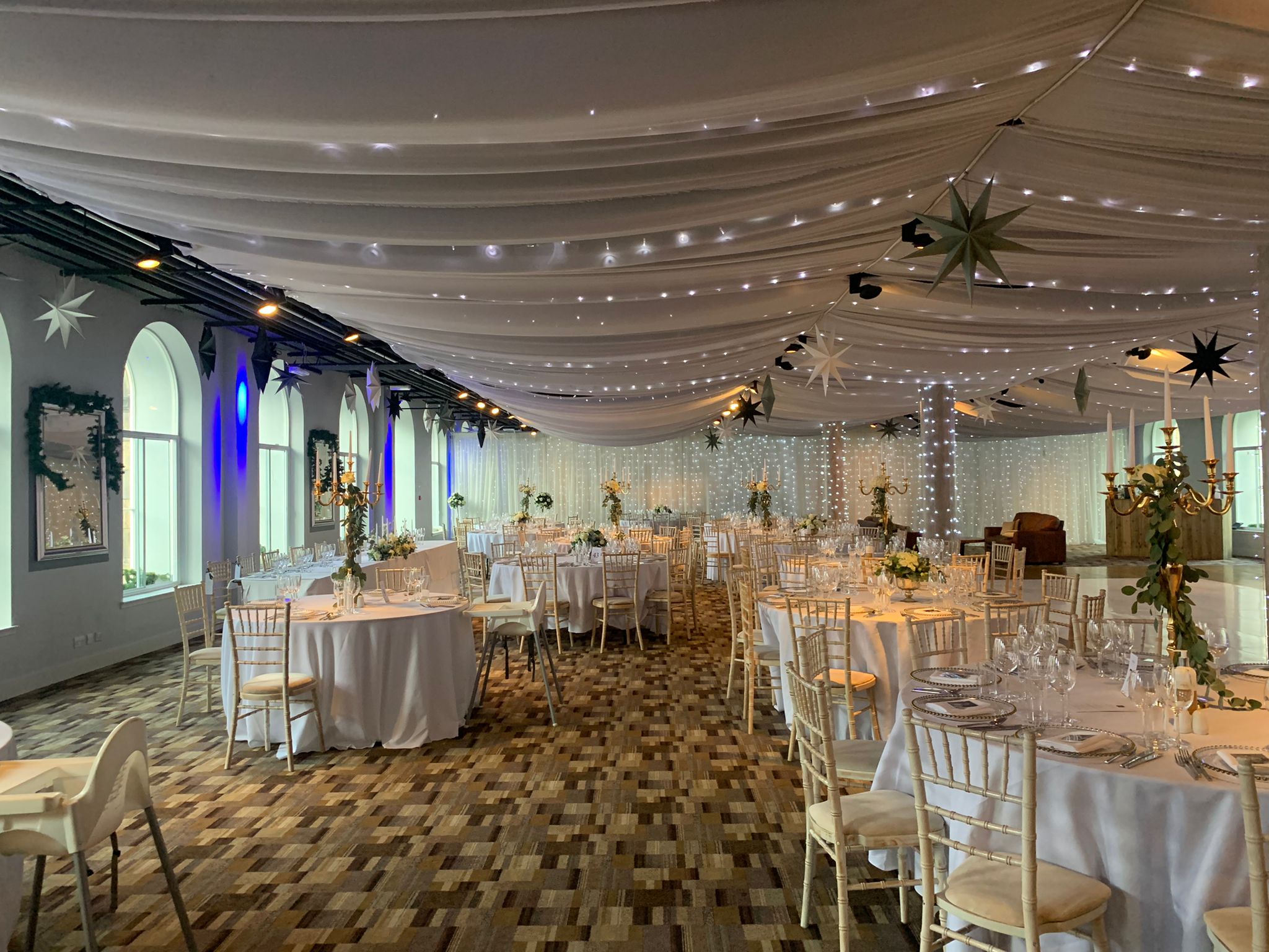 Elegant event space with round tables, ideal for weddings and corporate gatherings.