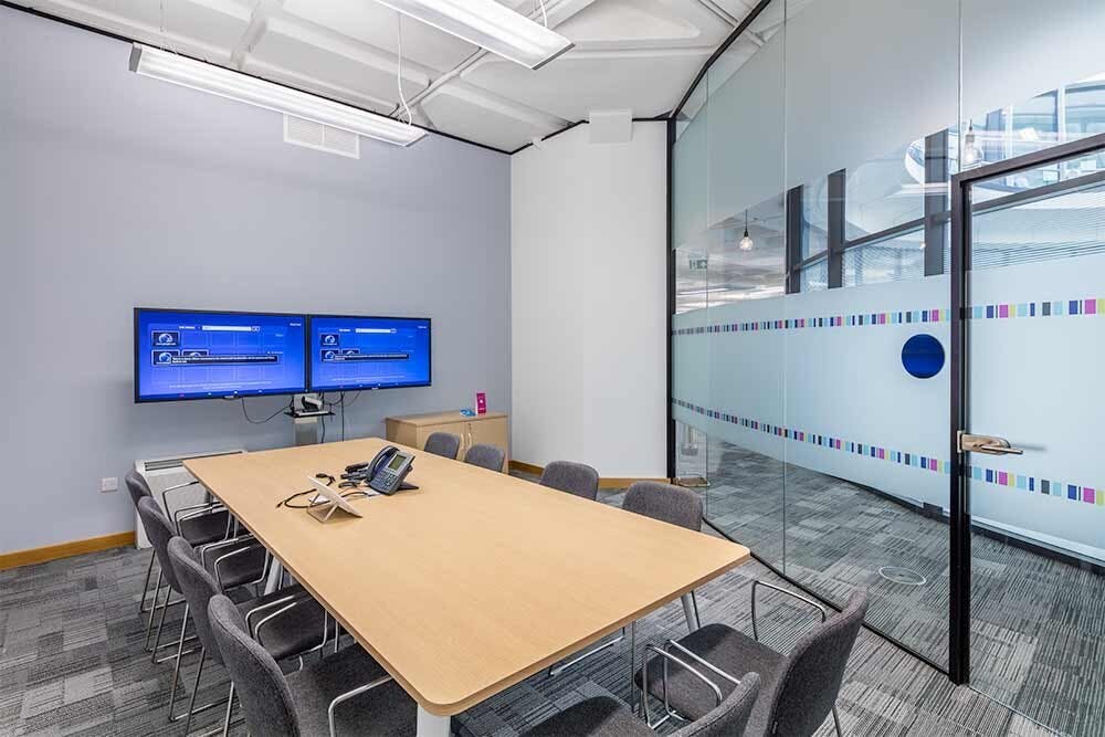 Modern meeting room with ergonomic chairs in bright, cheerful office space for collaboration.