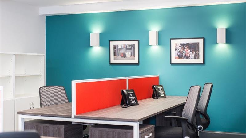 Modern meeting room with turquoise wall, ideal for collaborative brainstorming sessions.