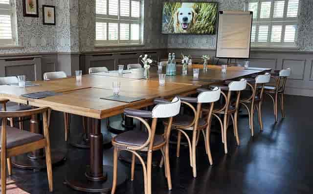 Private function room with wooden table, ideal for workshops and meetings.