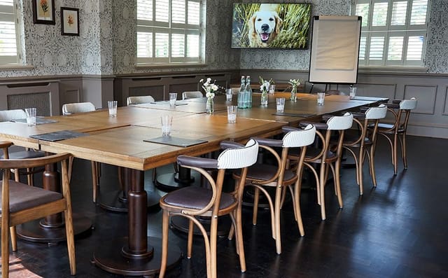 Private function room with wooden table, ideal for workshops and meetings.