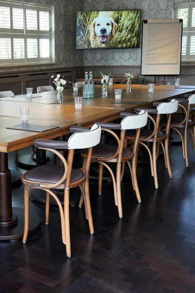 Private function room with long wooden table, ideal for meetings and events.