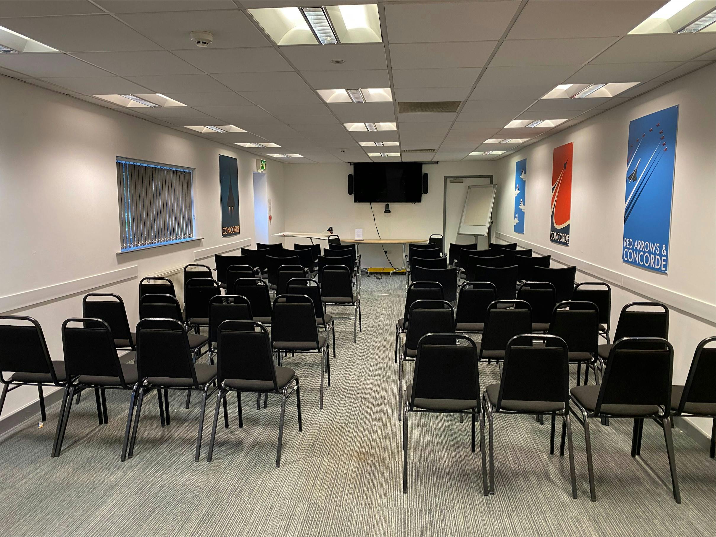 Versatile meeting space with black chairs for presentations at Concorde Conference Centre.