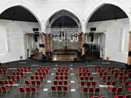 Modern event venue with large stage and seating for conferences or performances.