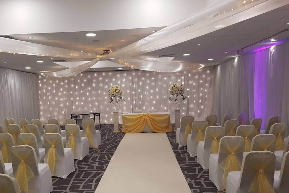 Elegant wedding event space at Village Hotel Bury with white and gold decor.