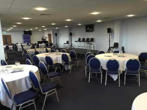 Versatile event space in Oldham with round tables, ideal for meetings and banquets.