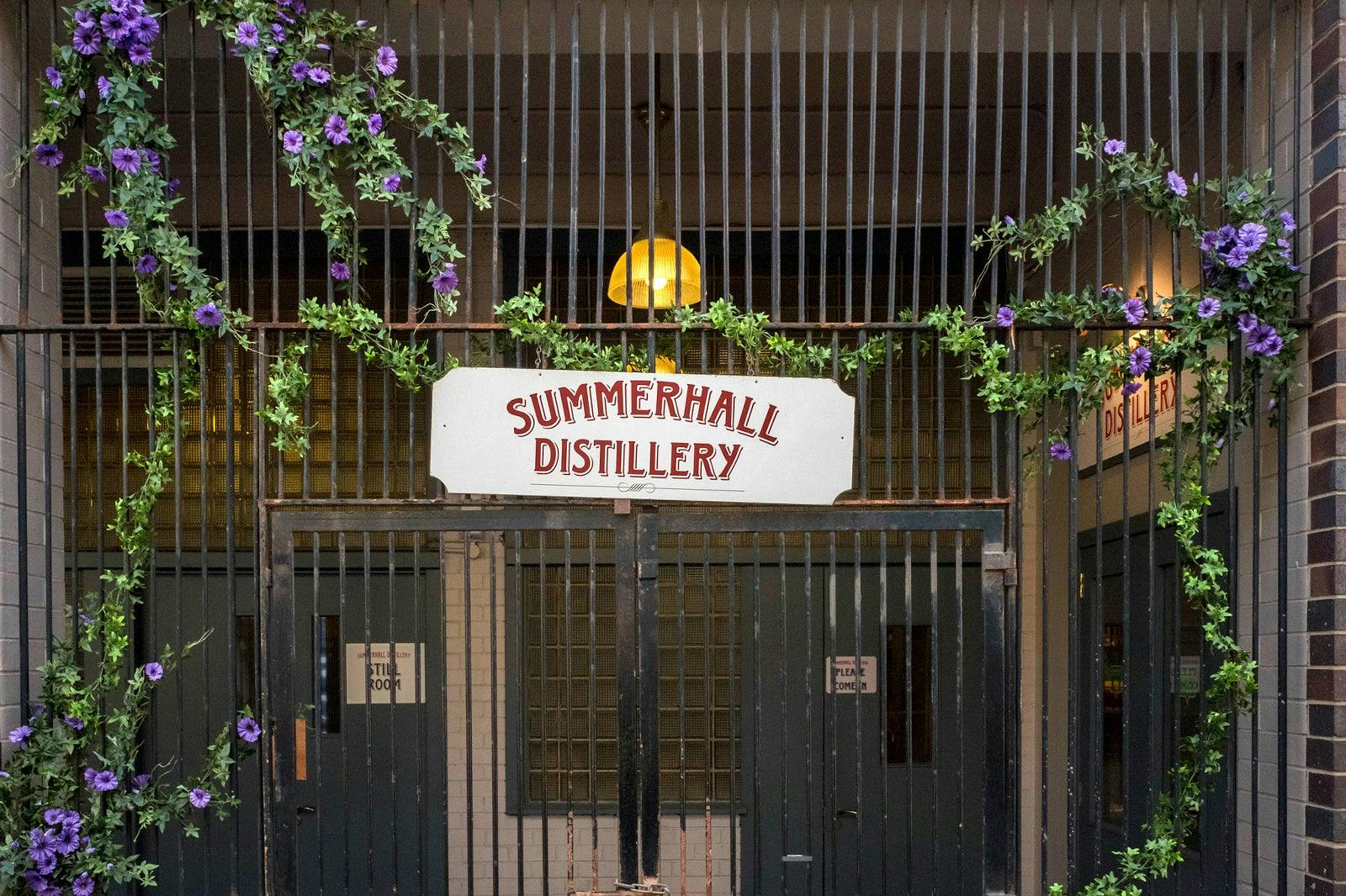 Charming Summerhall Distillery entrance with purple flowers, perfect for events and tastings.