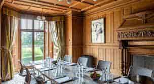 Sophisticated meeting room with wood paneling, ideal for executive meetings and events.