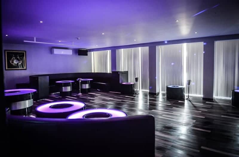 Modern event space with purple lighting, ideal for meetings and social gatherings.