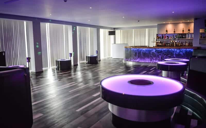Modern event space with circular tables and purple lighting at The Sheridan.