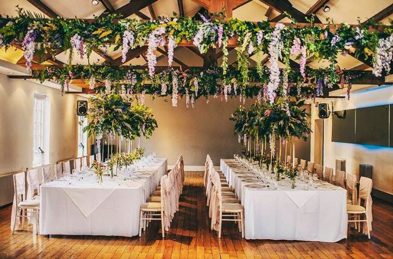 Elegant event space with long tables, greenery, perfect for weddings and upscale gatherings.