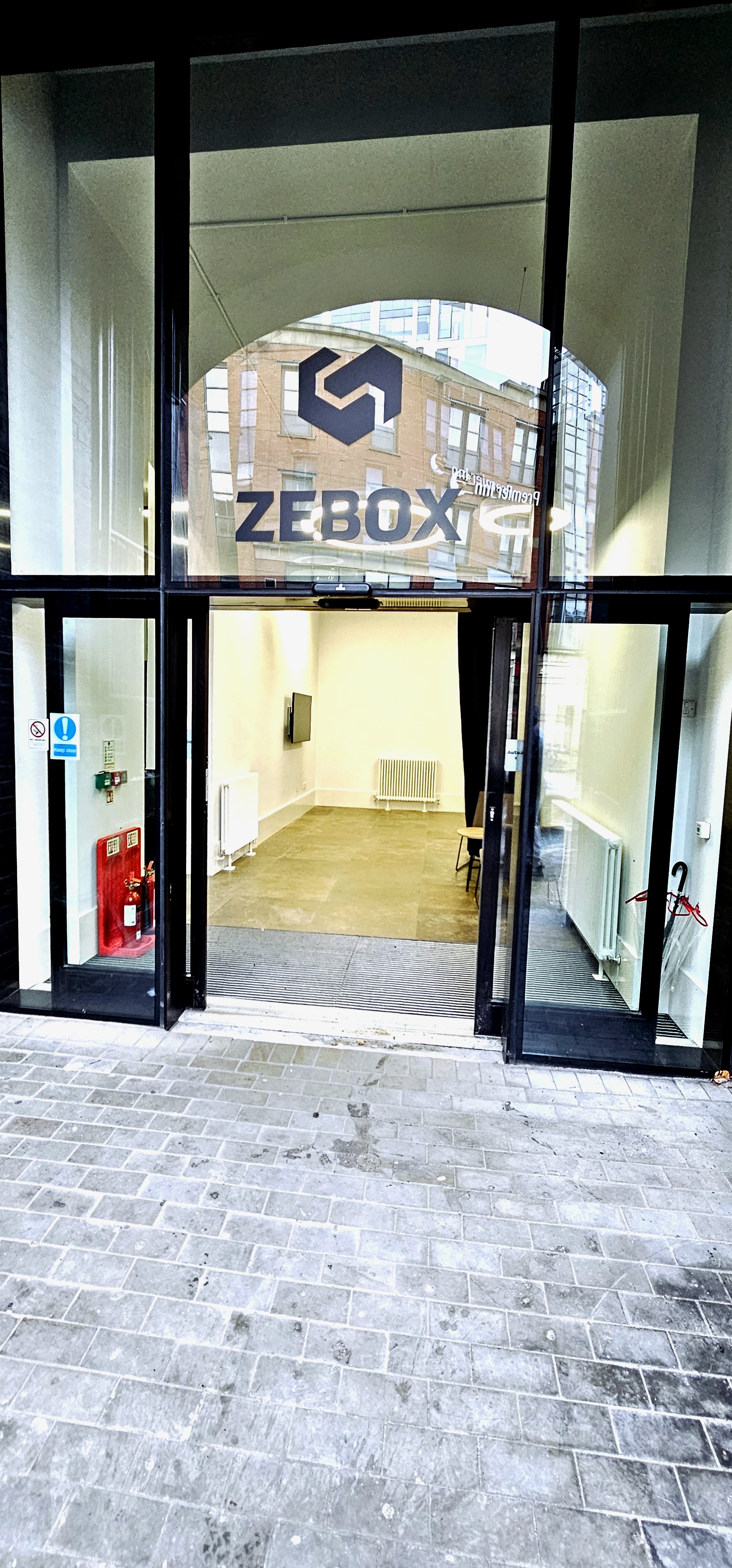 Minimalist meeting space in ZEBOX UK with natural light, ideal for gatherings and presentations.