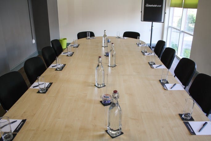 Meeting room at Castlefield Hotel with long table, ideal for workshops and strategic meetings.