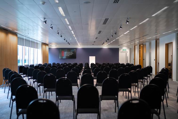 The Boardroom at Manchester Conference Centre, modern seminar space with black chairs. - Banner