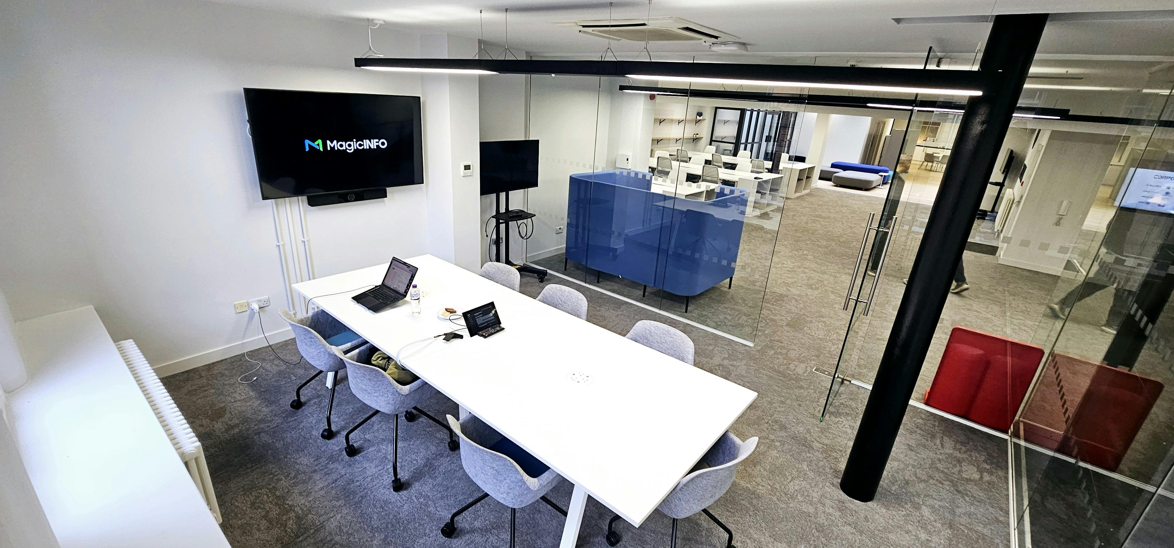 Modern meeting room with white table, glass walls for collaboration and brainstorming.