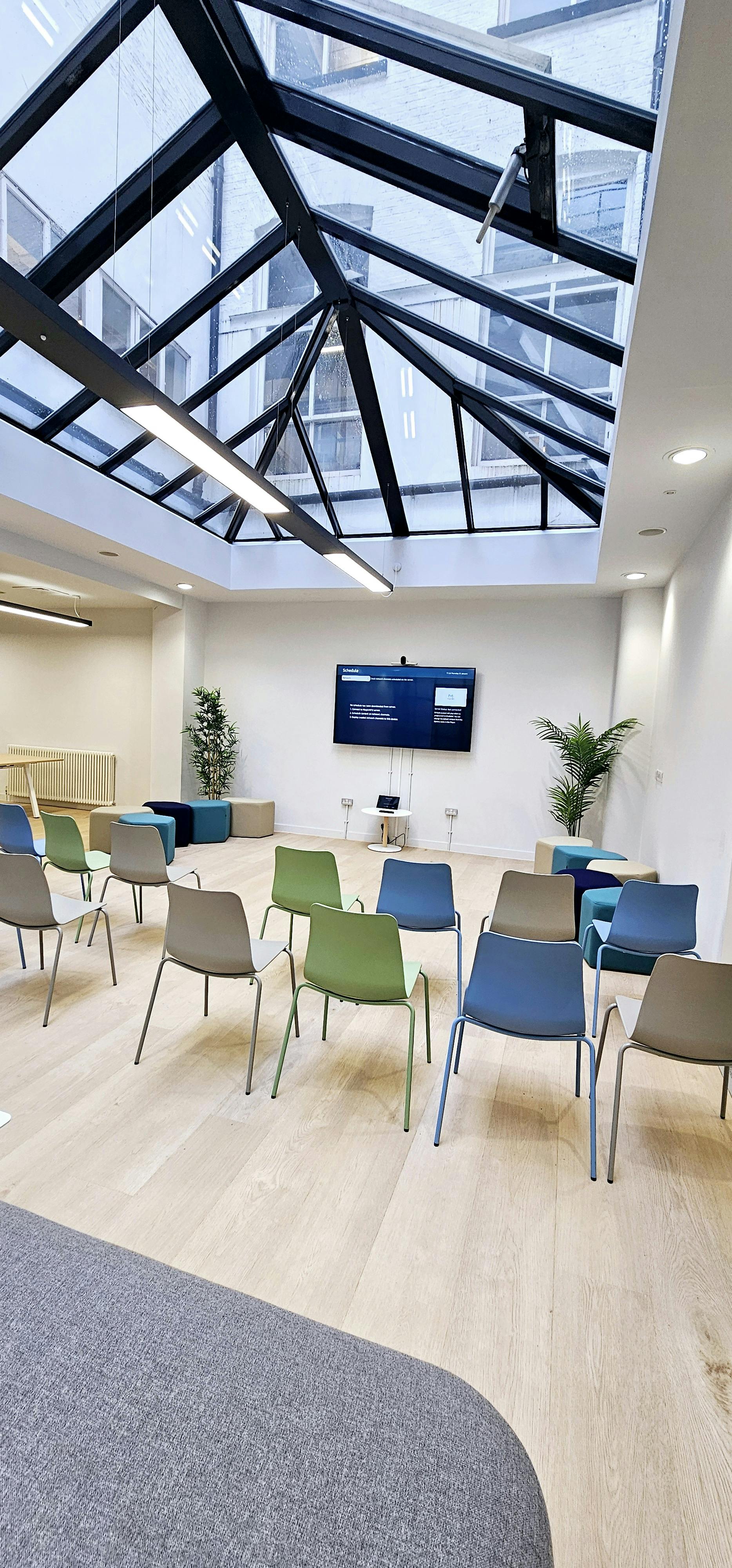 Versatile meeting space in ZEBOX UK with colorful chairs for workshops and team meetings.