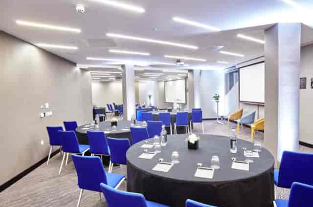 Modern meeting room in Marlowe with round tables, ideal for corporate workshops.