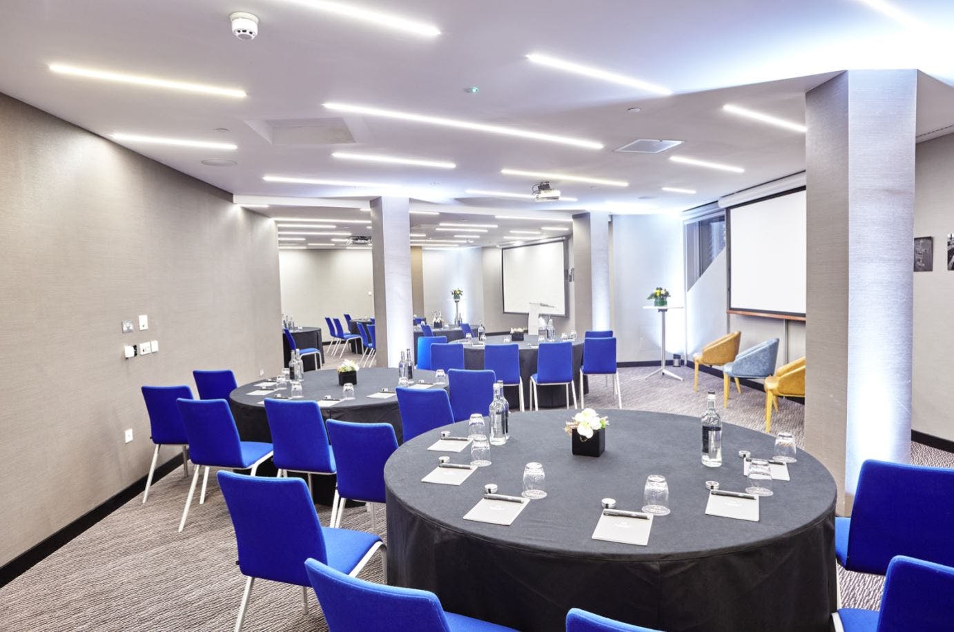 Modern meeting room with round tables, ideal for corporate events and workshops.