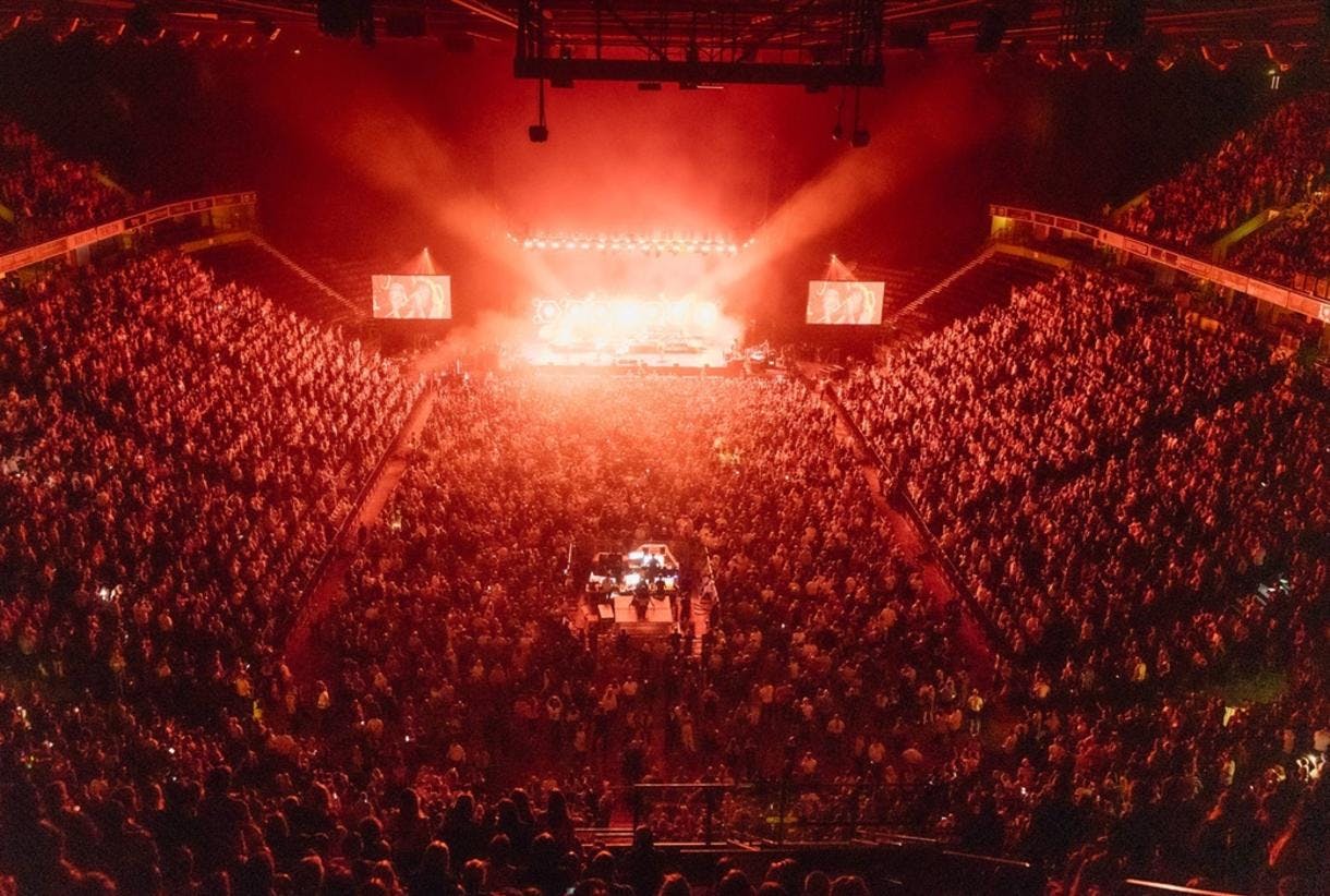 Packed AO Arena bowl with vibrant lights, perfect for large-scale events and meetings.